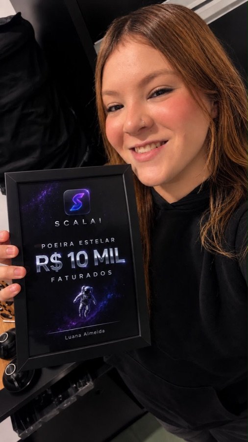 Aluna sorrindo com a placa Poeira Estelar de R$ 10 mil faturados